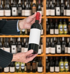 Sommelier offering bottle of red wine to customer