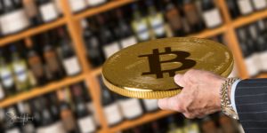 Businessman offering a bitcoin in payment for bottles of wine in wine store or supermarket in concept for e-commerce